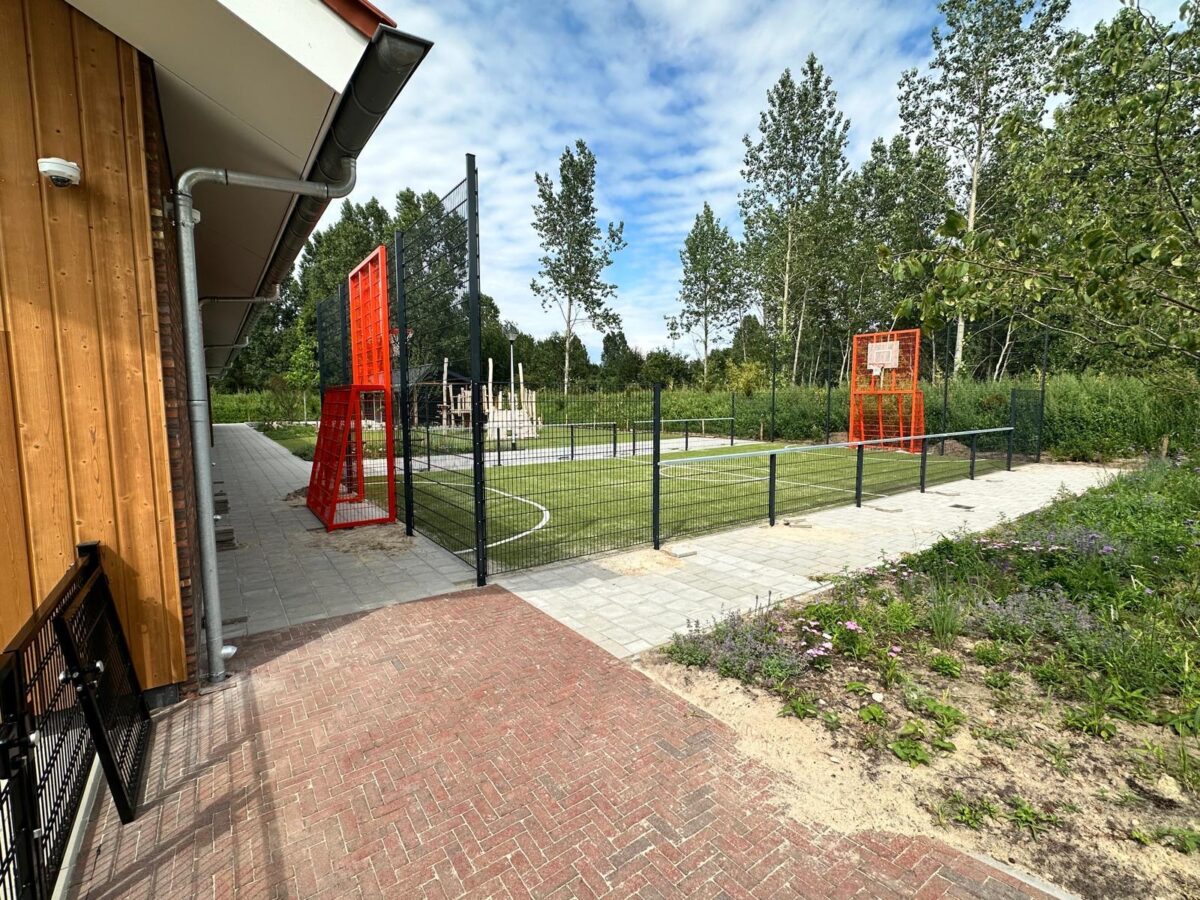 Sportkooi met voetbal- en basketbalcombinatie geplaatst bij Herderscheeschool Almelo 7 Pannakooi in RAL 7016 met basketbalunits in RAL 2004 en voetbaldoelen in Almelo.
